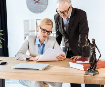 Employees in a law firm look at a printed document.