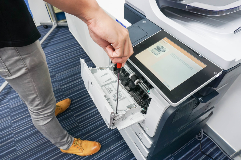 A technician fixing a printer.