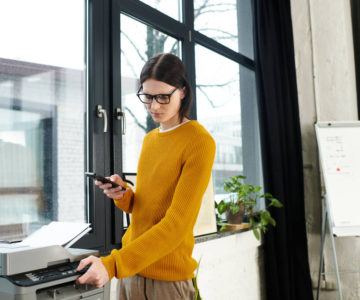 An employee checking the connection of the office printer.