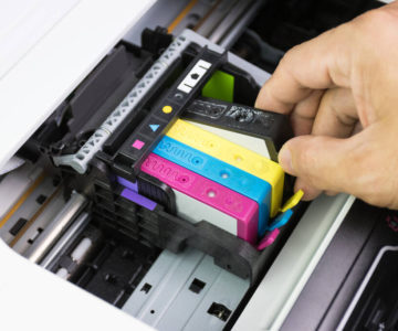 An individual taking out a printer cartridge.