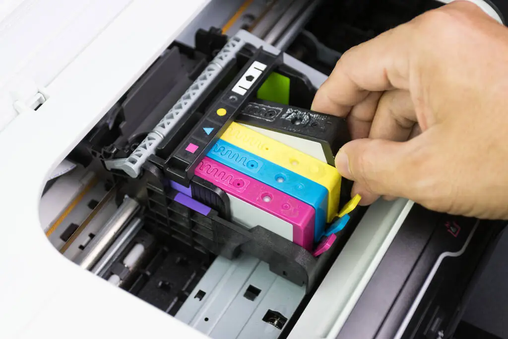 An individual taking out a printer cartridge.